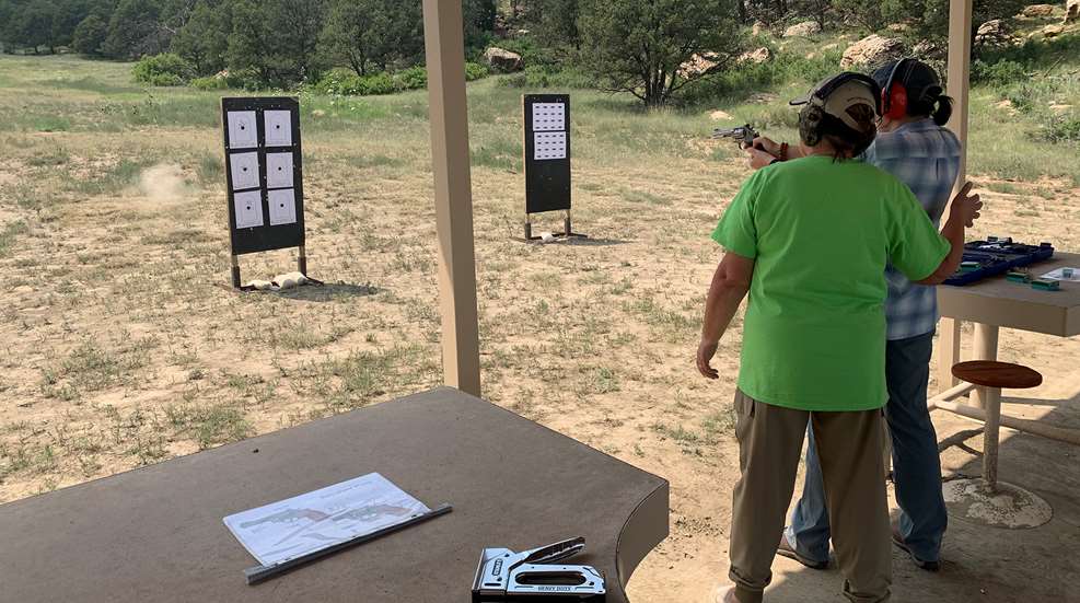 Woman Instructing Woman Shooting Pistol