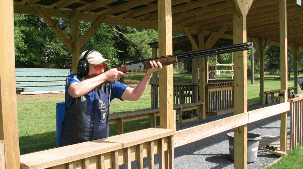 Woman Shooting Shotgun At Range