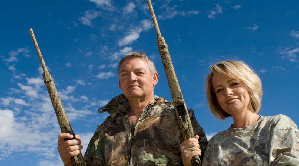 Man And Woman In Camo Holding Rifles