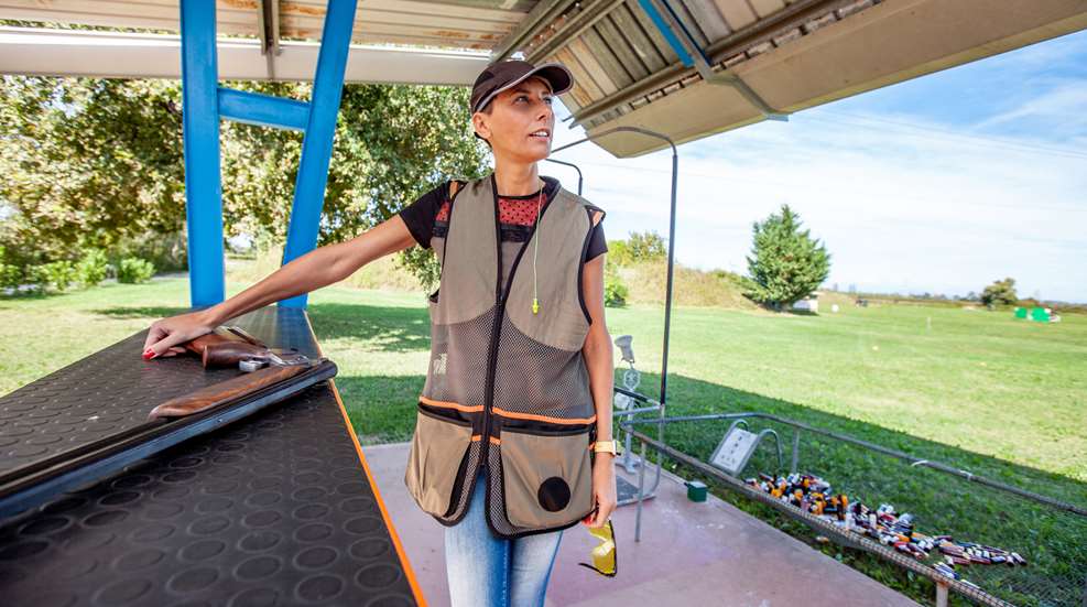 Woman Standing At Station With Shotgun