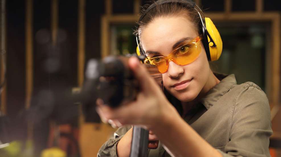Female Aiming Rifle On Range
