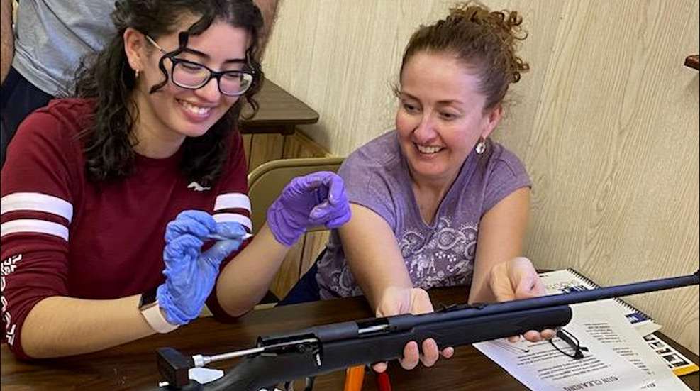 Two Women Cleaning Rifle