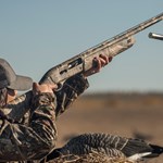 Woman Wingshooter In Camo Pointing Shotgun