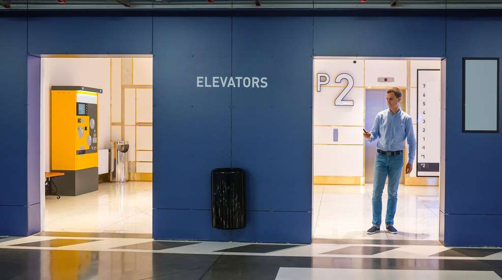 Man Standing Near Elevators At Parking Garage