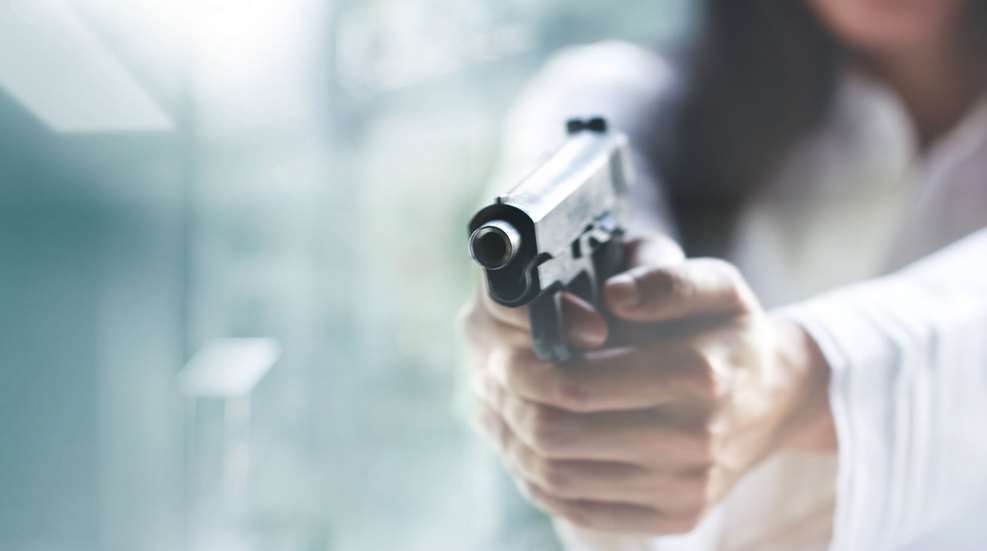 woman holding pistol at attacker