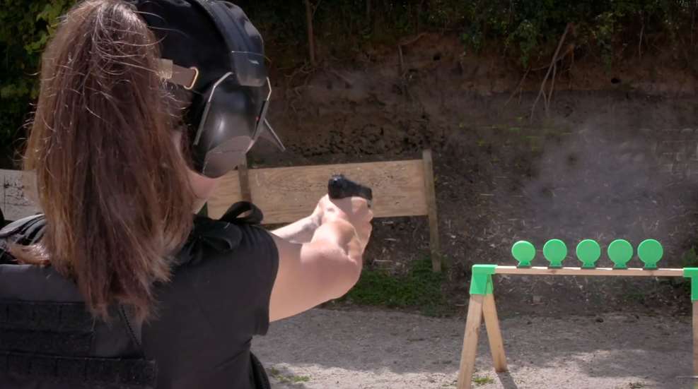 Woman Shooting Handgun At Throom Targets