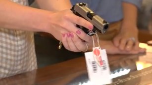 Woman Trying Gun At Counter